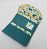 Slim Tri-fold wallet in teal vinyl with sunflower yellow piping, vinyl interior card slots and cotton lining